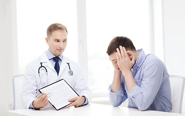 Image showing doctor with clipboard and patient in hospital