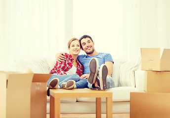 Image showing smiling couple relaxing on sofa in new home