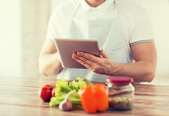 Image showing closeup of man reading recipe from tablet pc