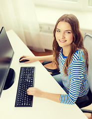 Image showing dreaming teenage girl with computer at home