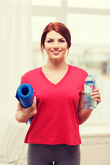 Image showing smiling girl with bottle of water after exercising