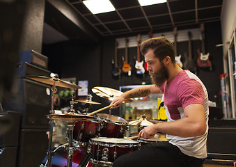 Image showing male musician playing cymbals at music store