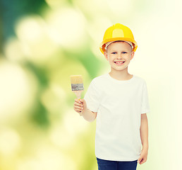 Image showing smiling little boy in helmet with paint brush