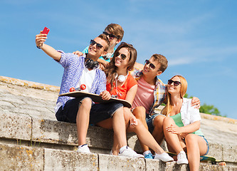 Image showing group of smiling friends with smartphone outdoors