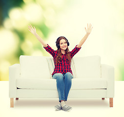 Image showing teenage girl sitting on sofa with headphones