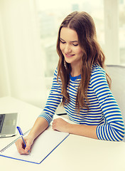 Image showing smiling teenage girl laptop computer and notebook