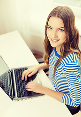 Image showing smiling teenage gitl with laptop computer at home