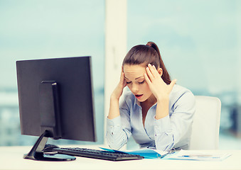 Image showing stressed woman with computer and documents