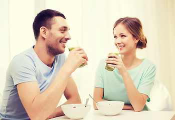 Image showing smiling couple having breakfast at home