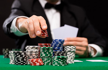 Image showing poker player with cards and chips at casino