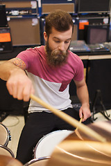 Image showing male musician playing cymbals at music store