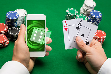 Image showing casino player with cards, smartphone and chips