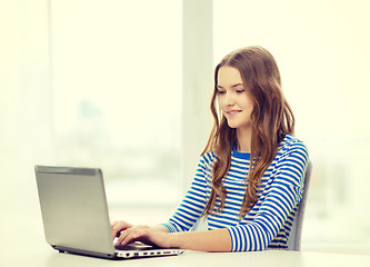 Image showing smiling teenage gitl with laptop computer at home