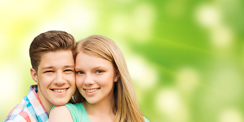 Image showing smiling couple hugging over green background