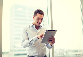 Image showing smiling businessman with tablet pc in office