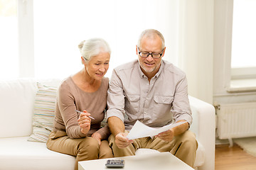 Image showing senior couple with papers and calculator at home