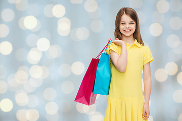 Image showing smiling little girl in dress with shopping bags