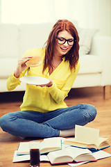 Image showing student eating hamburger and doing homework