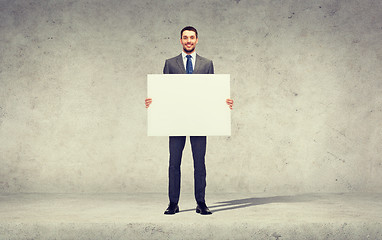 Image showing smiling businessman with white blank board