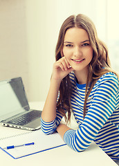 Image showing smiling teenage girl laptop computer and notebook