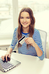 Image showing smiling teenage girl with laptop computer at home