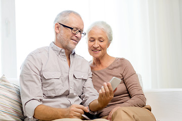 Image showing happy senior couple with smartphone at home