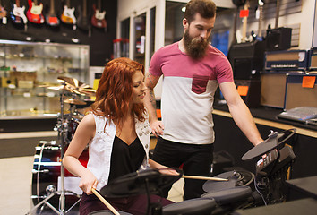 Image showing man and woman with drum kit at music store