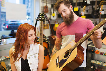 Image showing couple of musicians with guitar at music store