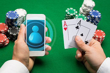 Image showing casino player with cards, smartphone and chips