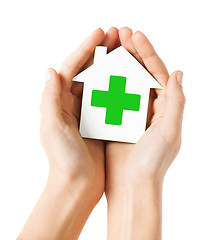 Image showing hands holding paper house with green cross