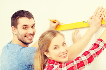 Image showing couple building using spirit level to measure