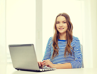 Image showing smiling teenage gitl with laptop computer at home