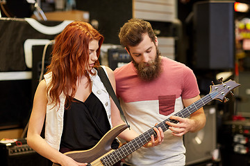 Image showing musicians playing bass guitar at music store