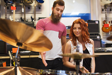 Image showing man and woman with drum kit at music store