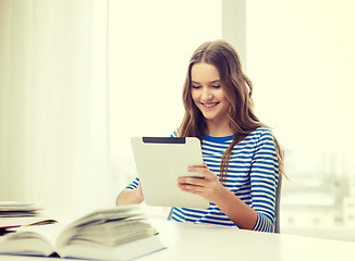 Image showing smiling student girl with tablet pc and books