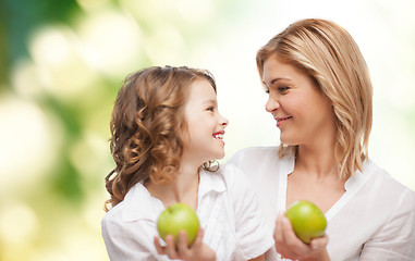 Image showing happy mother and daughter with green apples