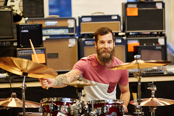 Image showing male musician playing cymbals at music store