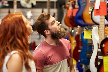 Image showing couple of musicians with guitar at music store