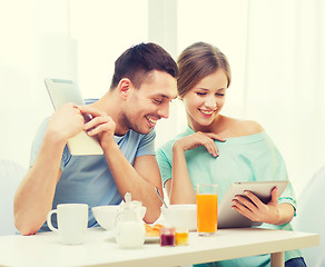 Image showing smiling couple with tablet pc reading news