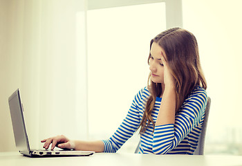 Image showing upset teenage gitl with laptop computer at home