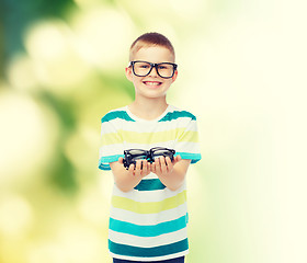 Image showing smiling boy in eyeglasses holding spectacles