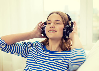 Image showing smiling young girl in headphones at home