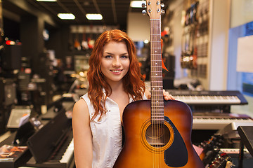 Image showing assistant or customer with guitar at music store