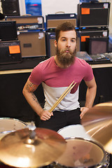 Image showing male musician playing cymbals at music store
