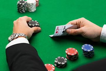 Image showing poker player with cards and chips at casino