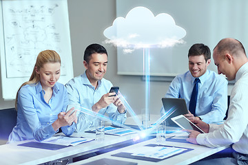 Image showing smiling business people with gadgets in office