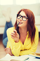 Image showing smiling student girl reading books at home