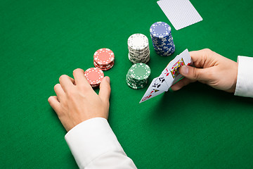 Image showing poker player with cards and chips at casino