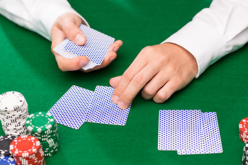 Image showing holdem dealer with playing cards and casino chips