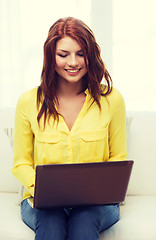 Image showing smiling woman with laptop computer at home